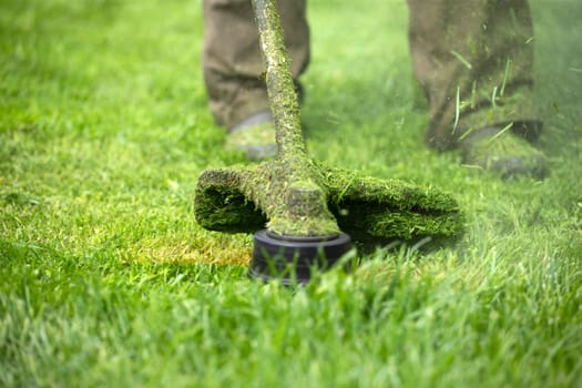 Mowing the grass with a lawn mower. Garden work concept background.