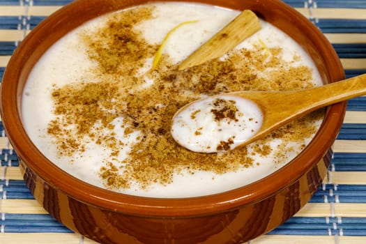 Dish of rice pudding with lemon scratches and with spoon