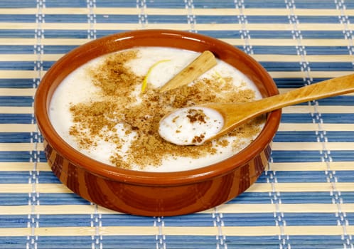 Dish of rice pudding with lemon scratches and with spoon