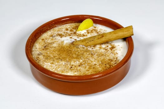 Dish of rice pudding with grated cinnamon, with lemon scratches