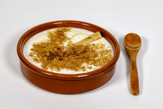Dish of rice pudding with lemon scratches and with spoon