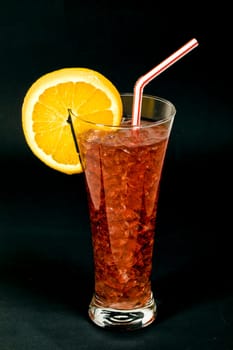 Refreshing typical sangria drink from Spain, with ice Orange slice on black background