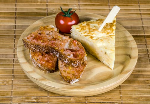 Spanish tortilla skewer presented in typical ration of Spain, With pure olive oil salt and bread with tomato