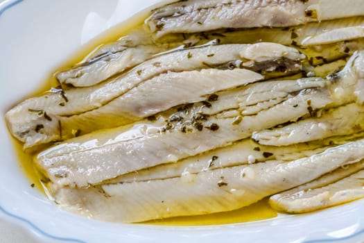 a pile of anchovies in vinegar isolated on a white background