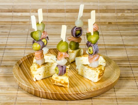 Delicious Appetizer Plate with Salmon, anchovies and Olives. Spanish tortilla mounted