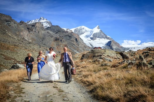 Zermatt, Switzerland, September 26, 2015: A small wedding party on a trail in Swiss Alps