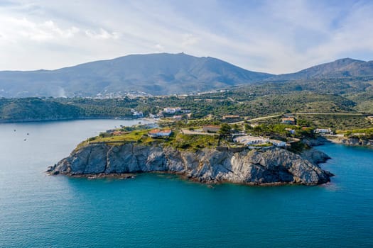Port Lligat in Spain with a tree in the foreground. Port Lligat is a village located on the Costa Brava at northeastern Catalonia in Spain. Salvador Dali lived in the village.