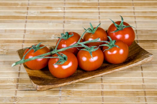 Bunch of branch tomatoes presented on bamboo tablet