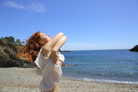Woman undressing on the beach ready to bath