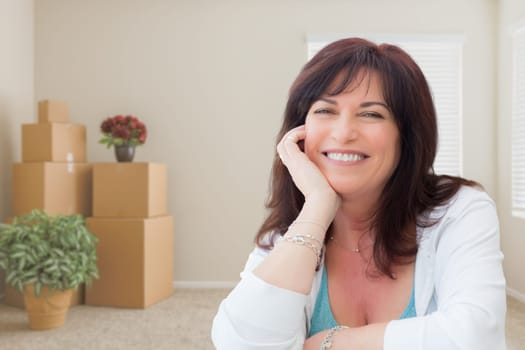Middle Aged Woman Relaxing Inside Empty Room With Moving Boxes.