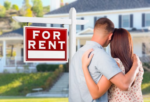 Military Couple Looking At House with For Rent Real Estate Sign In Front.