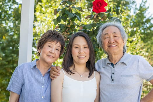 Chinese parents and Young Adult Daughter Outdoors.