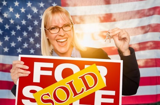 Young Woman Holding House Keys and Sold Sign In Front of American Flag