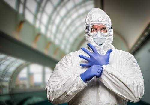 Man With Intense Expression Wearing HAZMAT Protective Clothing Inside Building.