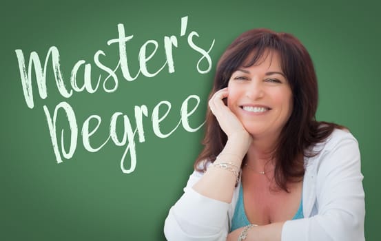 Master's Degree Written On Green Chalkboard Behind Smiling Middle Aged Woman.