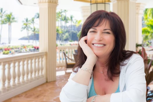 Attractive Middle Aged Woman Relaxing On Patio In A Tropical Travel Destination.