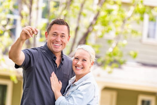 Caucasian Couple in Front of House with Keys.