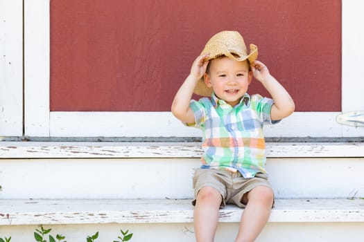 Young Mixed Race Chinese and Caucasian Boy Wearing Cowboy Hat Relaxing On The Steps