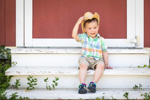 Young Mixed Race Chinese and Caucasian Boy Wearing Cowboy Hat Relaxing On The Steps