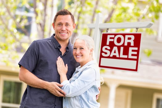 Caucasian Couple in Front of For Sale Real Estate Sign and House