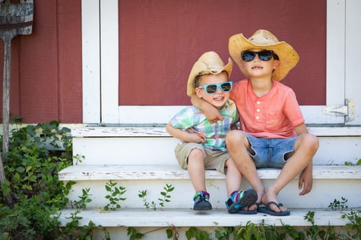 Mixed Race Chinese and Caucasian Young Brothers Having Fun Wearing Sunglasses and Cowboy Hats