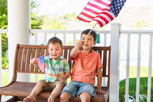 Young Mixed Race Chinese and Caucasian Brothers Playing With American Flags