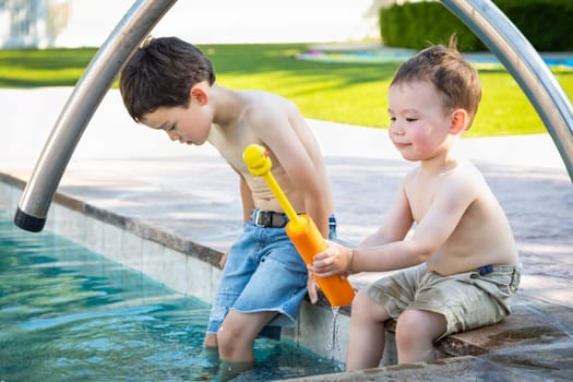 Young Mixed Race Chinese and Caucasian Brothers Playing At The Pool