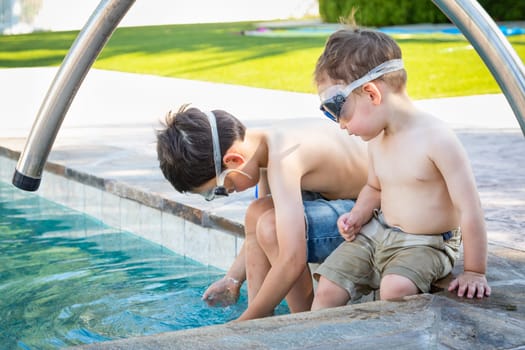 Young Mixed Race Chinese and Caucasian Brothers Wearing Swimming Goggles Playing At The Pool