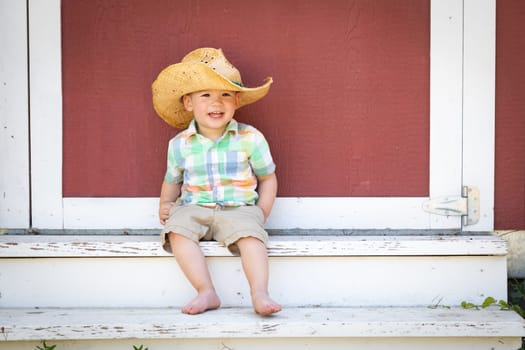 Young Mixed Race Chinese and Caucasian Boy Wearing Cowboy Hat Relaxing On The Steps