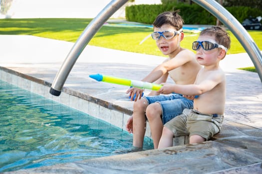 Young Mixed Race Chinese and Caucasian Brothers Wearing Swimming Goggles Playing At The Pool