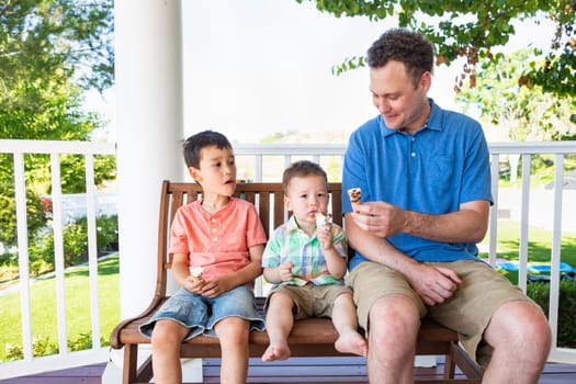 Caucasian Father Sitting With His Mixed Race Chinese and Caucasian Boys Enjoying Ice Cream Cones