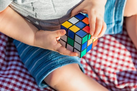 Baby Boy Sitting on Picnic Blanket Playing With Cube Puzzle