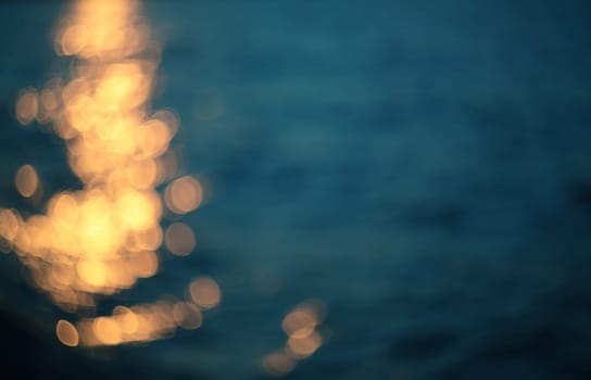 Golden sunlights on blue water background.