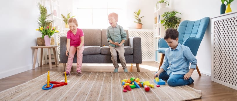 Playful children sitting in the living room on the Birthday party. Concept of the human relationship and friendship.
