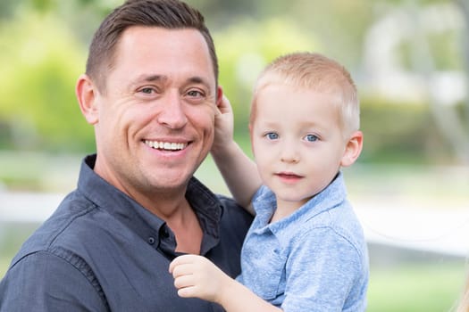 Young Caucasian Father and Son Having Fun At The Park.