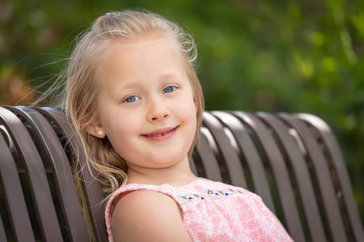 Pretty Young Caucasian Girl Portrait Sitting On The Bench At The Park.