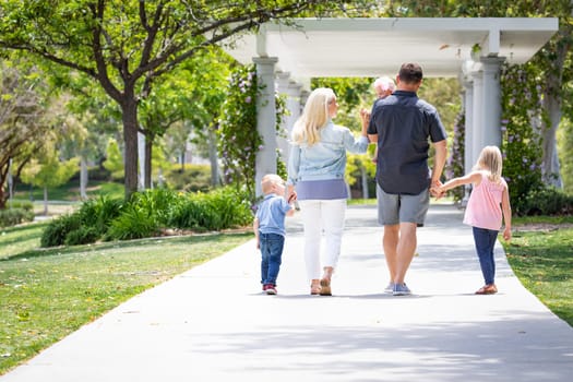 Young Caucasian Family Taking A Walk In The Park.