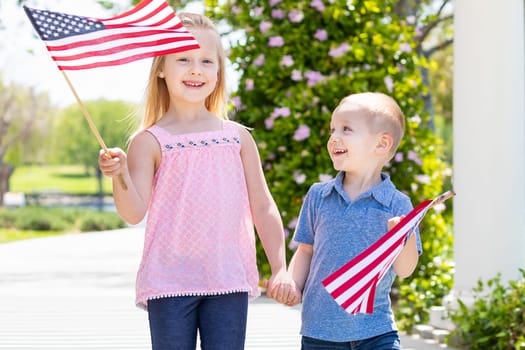 Young Sister and Brother Waving American Flags At The Park.