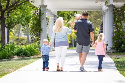 Young Caucasian Family Taking A Walk In The Park.