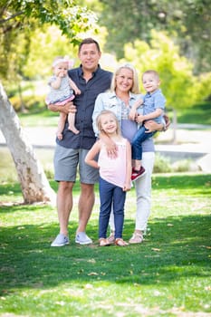 Happy Young Caucasian Family Portrait In The Park.