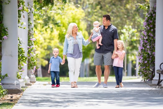 Young Caucasian Family Taking A Walk In The Park.