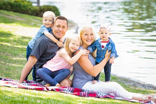 Happy Young Caucasian Family Portrait In The Park.