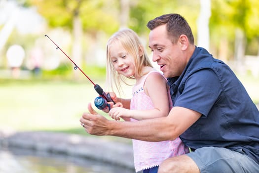 Young Caucasian Father and Daughter Having Fun Fishing At The Lake.