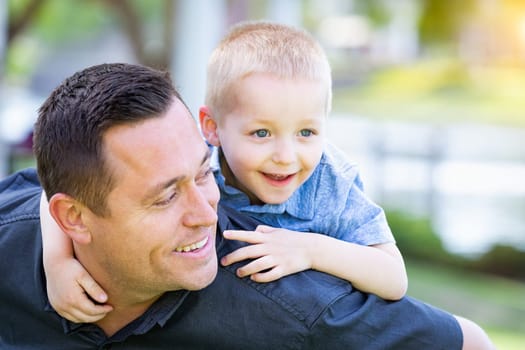Young Caucasian Father and Son Having Fun At The Park.