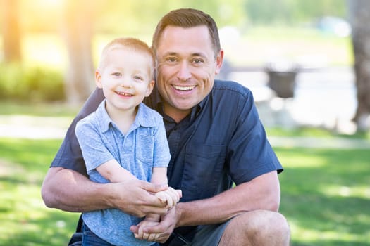 Young Caucasian Father and Son Having Fun At The Park.