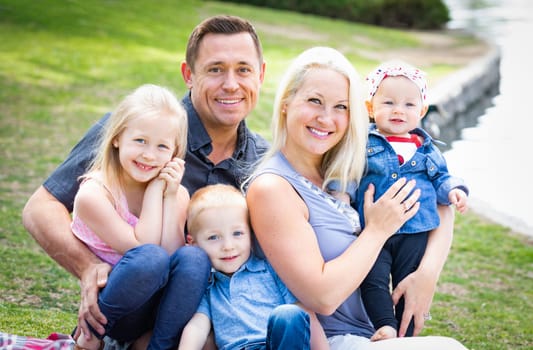 Happy Young Caucasian Family Portrait In The Park.