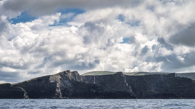 Tall Kerry Cliffs with dramatic sky, seen from a boat on Atlantic Ocean on a summer day, Portmagee, Iveragh Peninsula, Ring of Kerry, Ireland