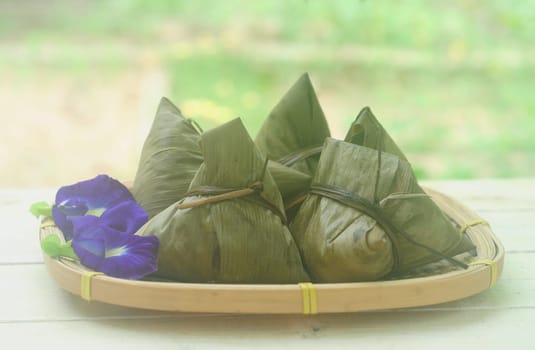 Chinese tradition food - Chinese Steamed Rice Dumpling  with blur background outdoor.Zongzi or traditional chinese sticky rice dumpling usually taken during festival occasion.