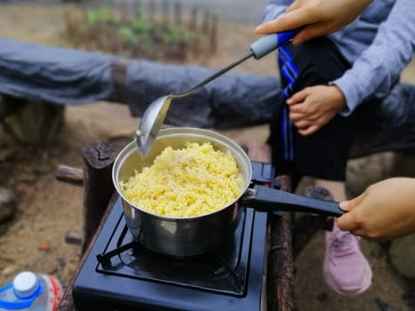 Cooking breakfast on campfire in cast iron pan with selective focus.