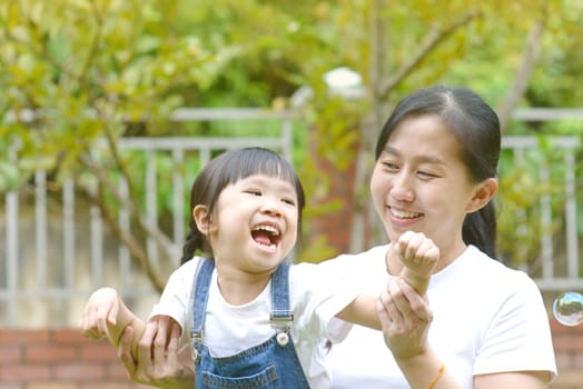 Enjoying time together.Lifestyle portrait asian mother and daughter in happines at the outside of garden park.
